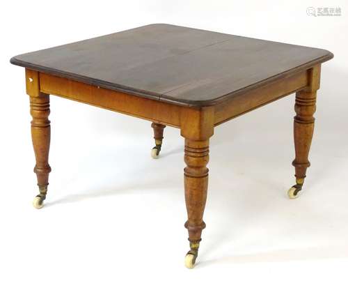 A Victorian mahogany dining table with moulded square top,