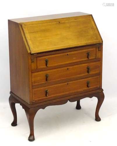 An Edwardian inlaid bureau with fall front opening to reveal pigeon holes and single short drawer