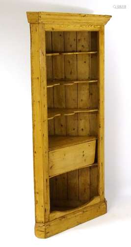 A late 18thC / early 19thC pine corner cupboard with moulded cornice above shaped shelves and drop