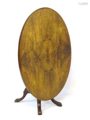A late 19thC walnut loo table with an oval marquetry inlaid top and decorative stringing,