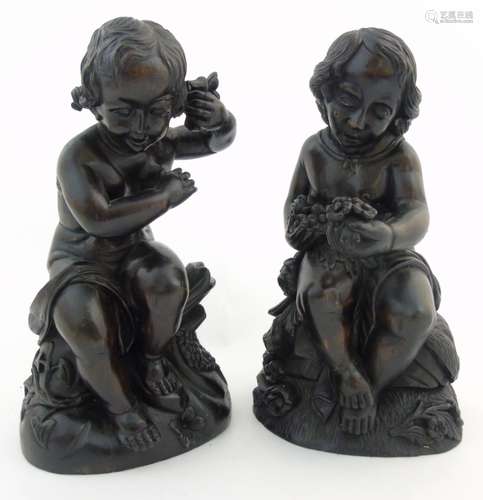 A pair of Victorian style carved wooden putti seated.