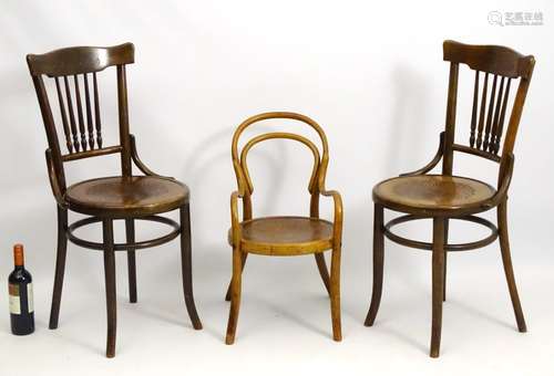 A pair of beech bentwood chairs with spindle back splats and anthemion decorated seats.