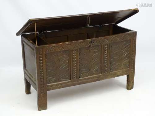 An 18thC oak three panel coffer with carved floral decoration to the front and opening to reveal