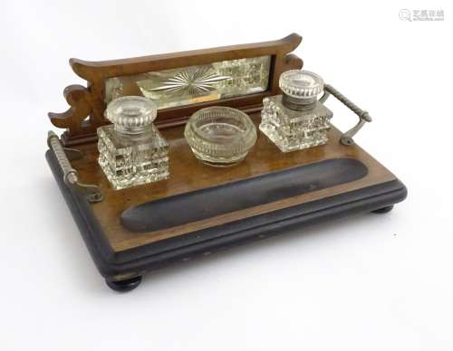 A Late Victorian walnut Standish with bevelled mirror back, glass inkwells and nib holder.