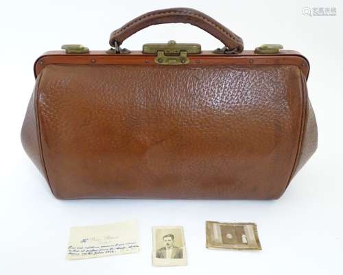 A small pigskin Gladstone bag with brass catches and lock,