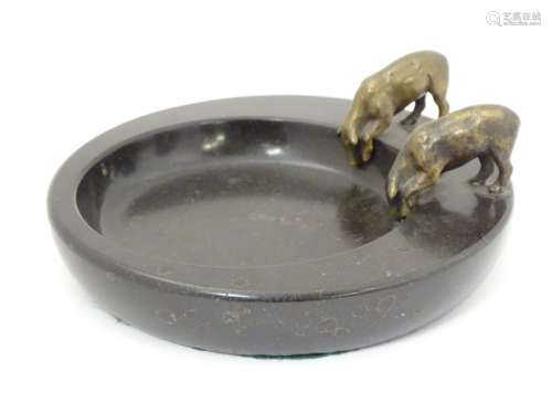 A cigar ashtray decorated with 2 bronze pigs drinking of a circular polished slate base 8 1/4