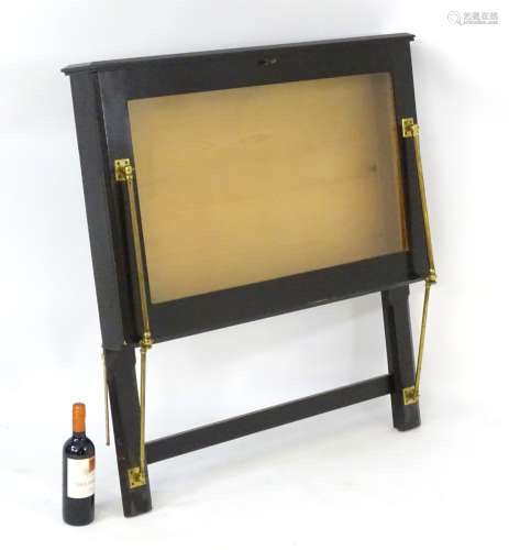 A late 20thC ebonised folio stand with glazed fall front. 38