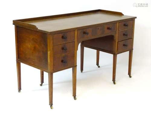 An early / mid 20thC mahogany desk / writing table with long central drawer flanked by three