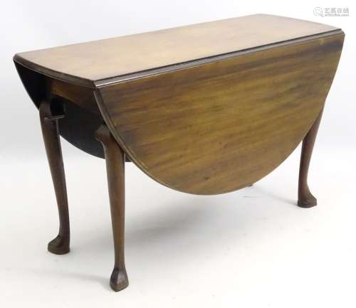 A mid 18thC walnut drop leaf table opening to reveal its oval form,