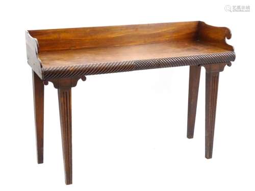 A William IV mahogany Irish serving table with scrolled up stand and carved front edge raised on