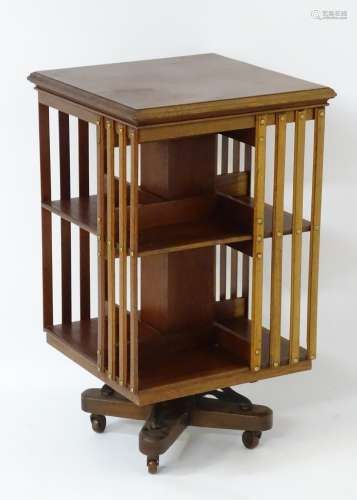 An early / mid 20thC mahogany revolving bookcase with slatted sides,