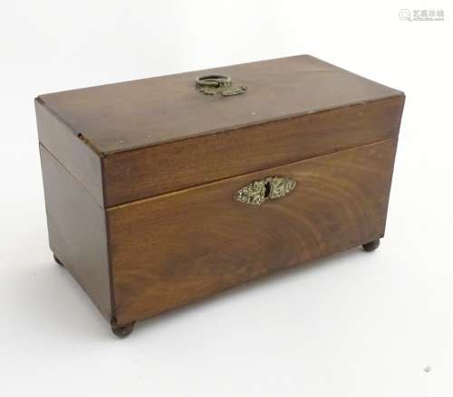 A late 18thC mahogany tea caddy with brass escutcheon, handle and standing on four feet.