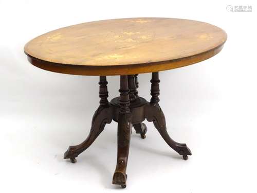 A late 19thC walnut loo table with an oval tilt top inlaid with floral decoration and decorative