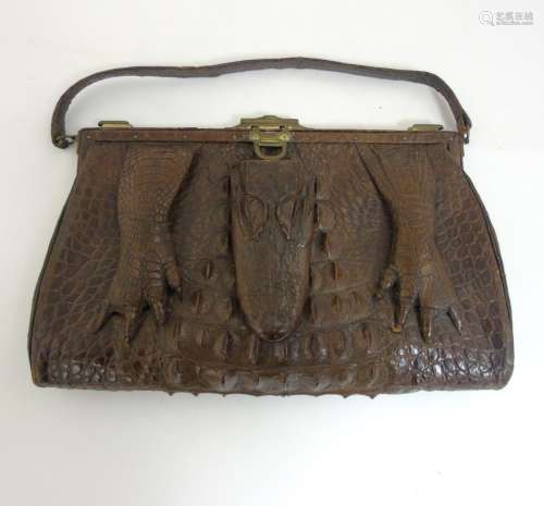 An early 20thC vintage ladies large crocodile skin handbag with head and feet decoration,