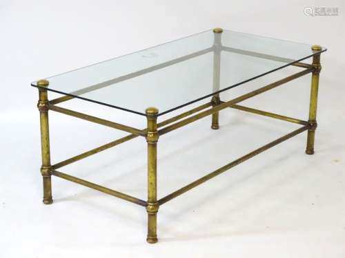A late 20thC industrial style brass and glass topped coffee table with double box stretcher