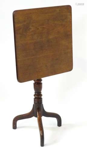 A late 18thC / early 19thC mahogany square tilt top table with an elegantly turned stem above three