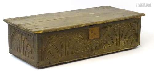 A 17thC oak box with an overhanging top above a scallop carved case.