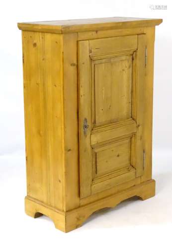 A late 20thC continental style cupboard with heavily moulded top edge above a single large panelled