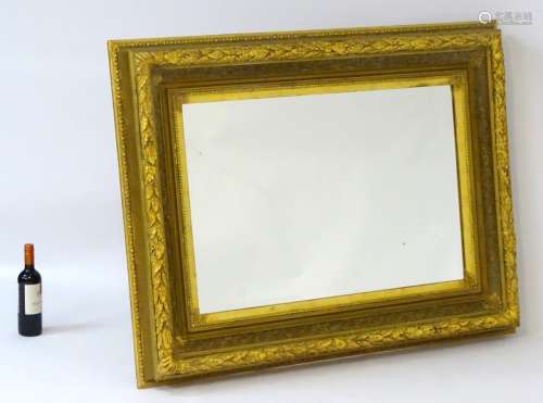 A 20thC large gilt mirror with decorative foliage border and beading.