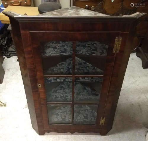 An antique figured mahogany corner cabinet, glazed door, canted corners, fitted shelves, 82 cm