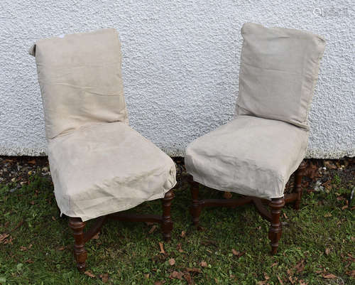 A pair of oak X-framed single chairs with covers (2)