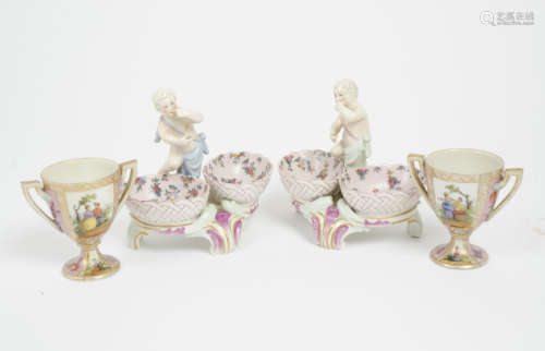 A pair of Dresden porcelain figural double salts, each with putto above baskets, blue crossed