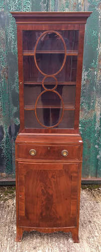 A 19th Century mahogany narrow bow-front cabinet, two sections, glazed upper bookcase section with