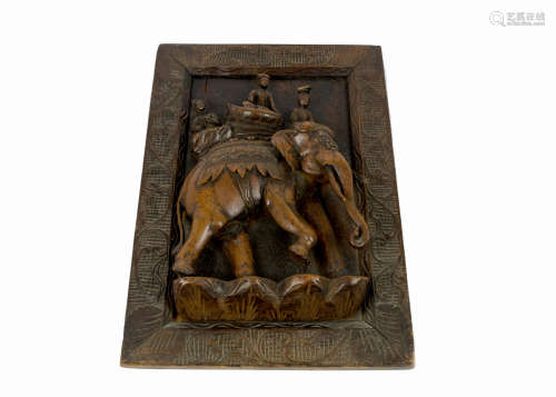 A 20th Century Indian carved wooden relief sculpture of three figures riding on an elephant, in a