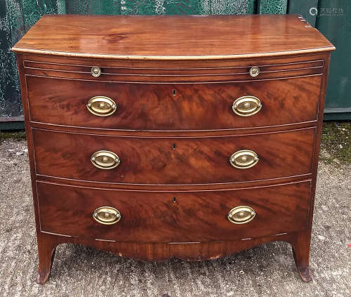 A 19th Century mahogany bow-front chest-of-drawers, three graduated long drawers and brushing slide,