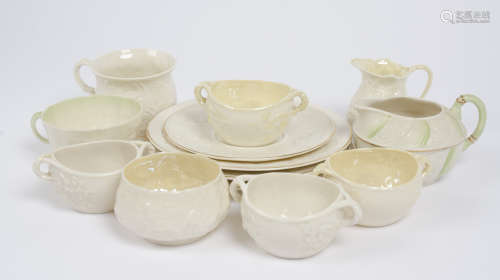 A collection of Belleek moulded porcelain tea bowls saucers and jugs, all with naturalistic
