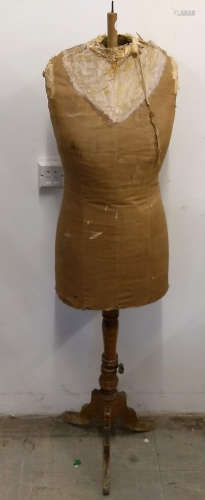 An early 1930s tailor's dummy, cloth covered papier mâché torso, turned pedestal on triform base,