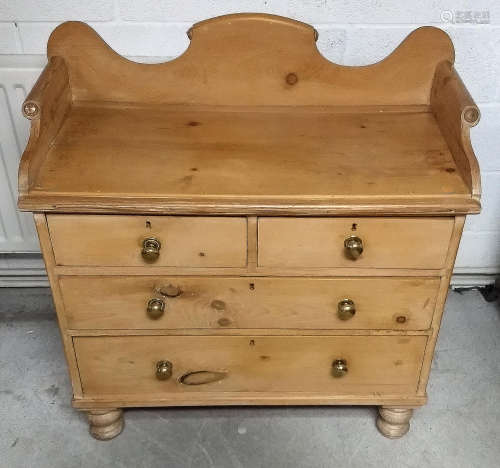 A 19th Century waxed pine wash stand, two short over two long drawers, roll-topped and shaped