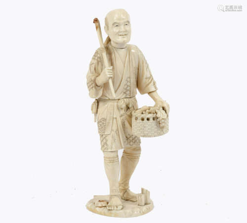 A Meiji period carved ivory figure of a farmer holding a scythe and basket of fruit and