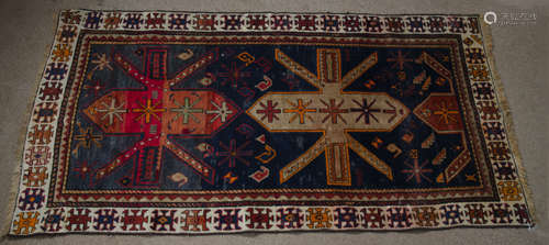 A Kazak woolen prayer rug, ivory, orange and terracotta geometric decoration on indigo field,