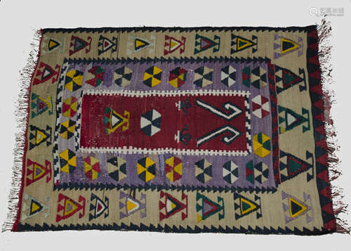 An early 20th century kelim rug, with geometric details surrounded in colourful borders, 83 x 112