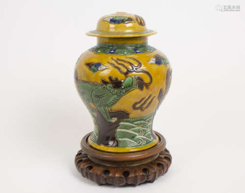 A large Chinese ginger jar and cover, decorated with temple dogs on a yellow background, character