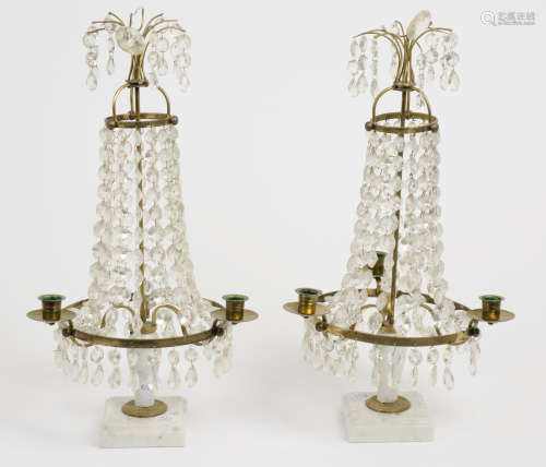 A pair of glass table candelabras, three brass arms, graduated glass prism drops surrounding brass