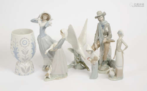 A collection of Lladro figures, consisting of a dove, a windswept woman, a musician and three farm
