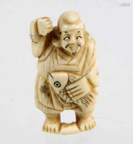 Netsuke um 1900Elfenbein von Hand beschnitzt, Japaner mit gefangenem Fisch, erhobene Hand mit Loch