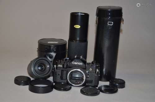 A Canon A1 SLR Camera and two Canon FD Lenses, serial no 110264, untested, finger grip cover missing