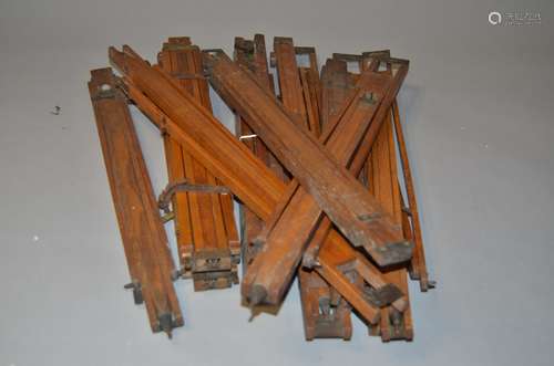 A Quantity of Individual Polished Wooden Legs, possibly easel or tripod legs with brass clamps and