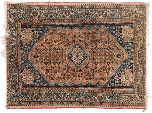 A Quashgai rug:, the shaded brick red field with a central indigo stepped medallion,