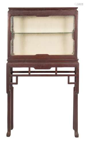 A Chinese hardwood rectangular display cabinet on a stand:, having glazed panel front,