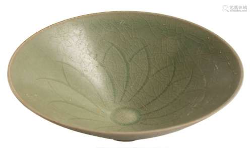 A Chinese celadon bowl: of flared conical form, the interior carved with a stylised lotus flower,