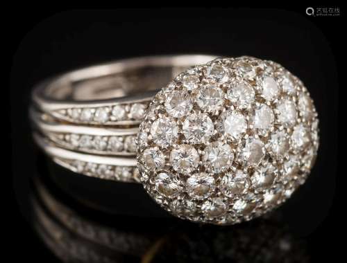 An 18ct white gold and diamond mounted oval bombe cluster ring: the raised oval cluster between