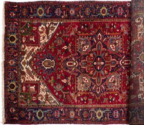 A Heriz rug:, the wine field with a central geometric lozenge flowerhead pole medallion,