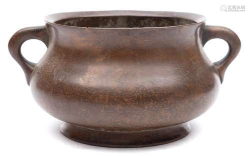 A Chinese bronze censer: the compressed circular body with angled rim, loop handles and flared foot,