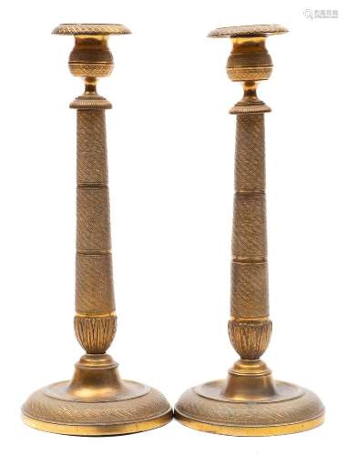 A pair of 19th century French brass candlesticks: with urn-shaped nozzles on spiral decorated
