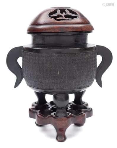A small Chinese bronze tripod censer: of oval form with flattened scroll handles,