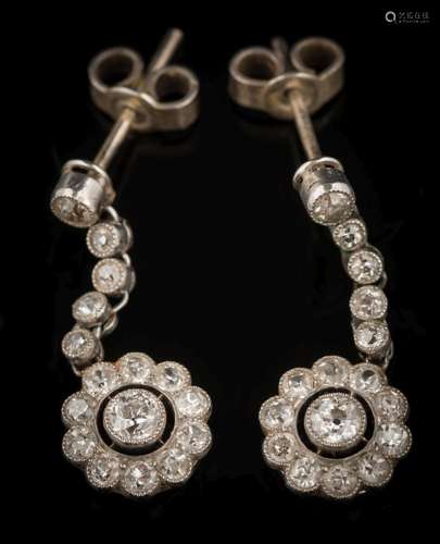 A pair of platinum and diamond pendant earrings: each with a circular cluster suspended by